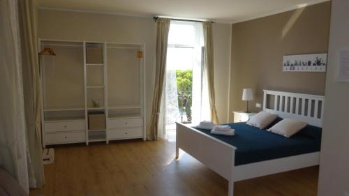 een slaapkamer met een bed en een groot raam bij Le camere della Nonna in Diano Marina