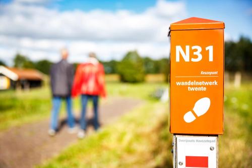 two people walking down a path with a sign on a trail at Stadshotel Rijssen in Rijssen