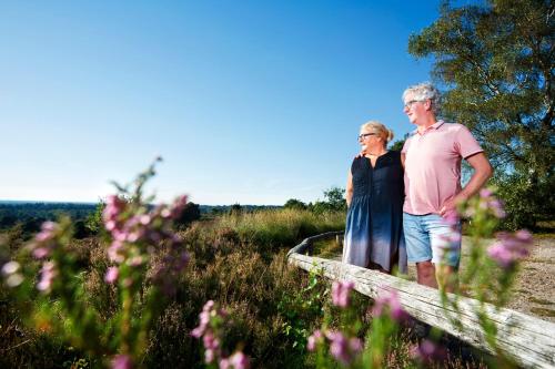 a man and woman standing in a field of flowers at Stadshotel Rijssen in Rijssen