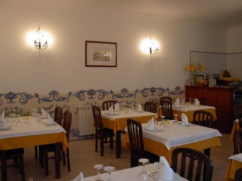 a dining room with tables and chairs and lights at Patio das Margaridas in Óbidos