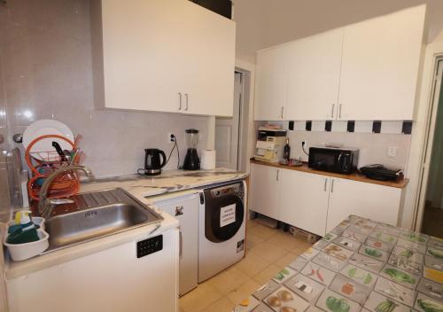 a kitchen with white cabinets and a sink and a stove at City Center Guest House in Lisbon