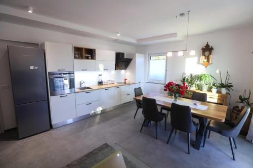 a kitchen and dining room with a table and chairs at Hisa dobrega pocutja in Kozina
