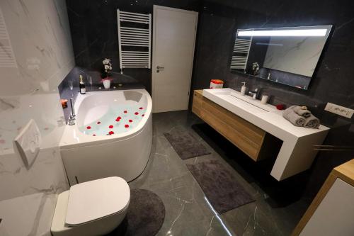 a bathroom with a tub and a toilet and a sink at Hisa dobrega pocutja in Kozina