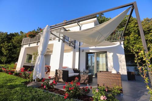 a house with a porch with a hammock in the yard at Hisa dobrega pocutja in Kozina