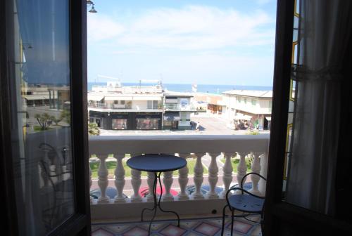 a balcony with a table and a view of the ocean at Villa Tina Hotel in Viareggio