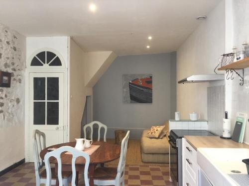 a kitchen and living room with a table and chairs at Le Petit Relais du Canal in Trèbes