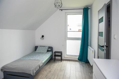 Un dormitorio pequeño con una cama y una ventana. en Wiatrem Pisane, en Władysławowo