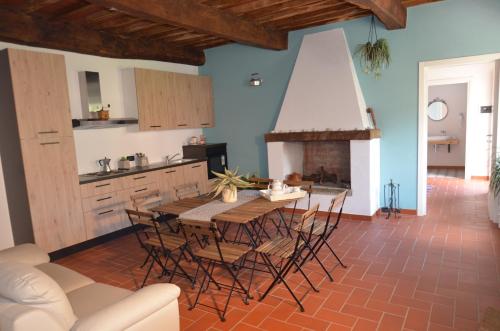 a kitchen with a table and chairs and a fireplace at La Casa Nell'Aia in Monsummano