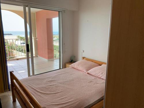 une chambre avec un lit et une vue sur l'océan dans l'établissement Mandana, au Cap d'Agde