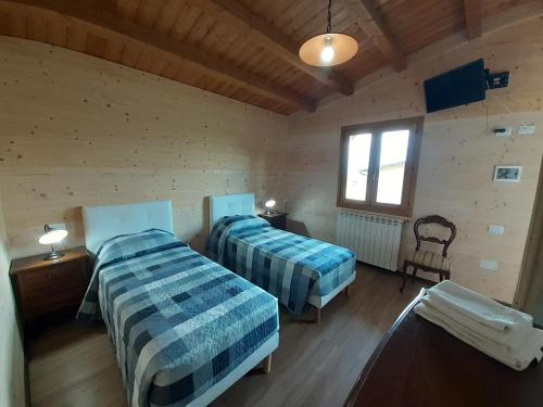 - une chambre avec 2 lits et une fenêtre dans l'établissement Agriturismo D'Apostolo, à Amatrice