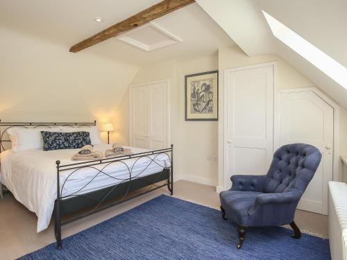 a bedroom with a bed and a chair at Kings Cottage - North in Broad Chalke