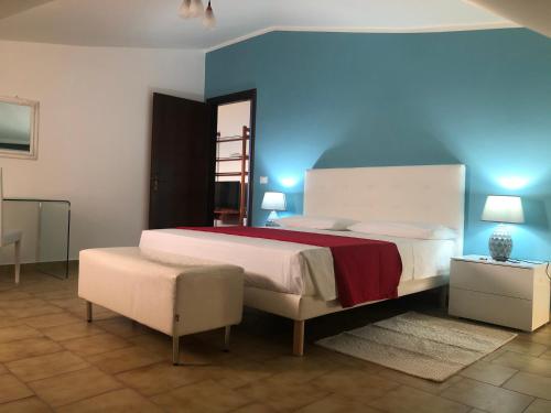 um quarto com uma cama grande e uma parede azul em B&B Altamarea em Falerna