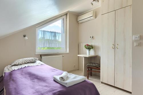 a bedroom with a purple bed and a window at Pensjon Polska in Poznań