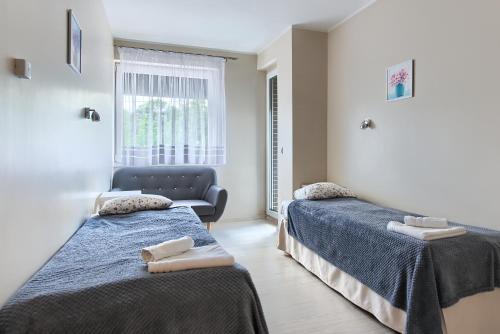a bedroom with two beds and a couch at Pensjon Polska in Poznań