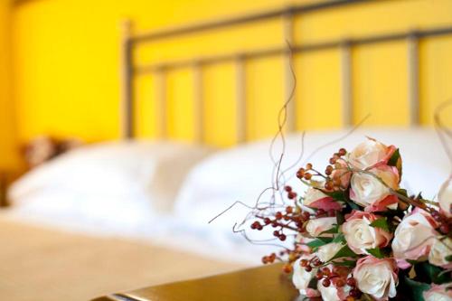 a bouquet of flowers on a table in front of a bed at Ospitalità Collicola in Spoleto