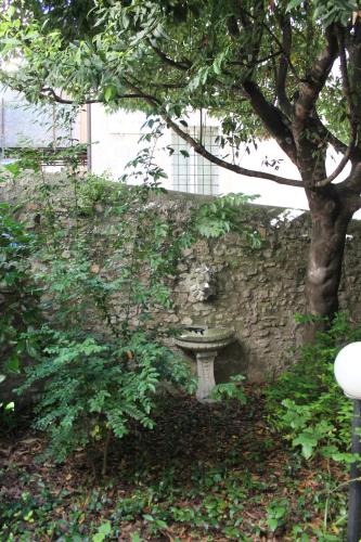 a stone wall with a bench next to a tree at Ospitalità Collicola in Spoleto