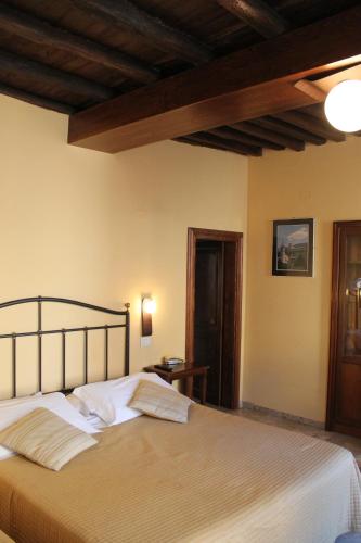 a bedroom with a large bed with a wooden ceiling at Ospitalità Collicola in Spoleto