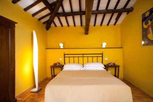 a bedroom with a large bed in a yellow wall at Ospitalità Collicola in Spoleto