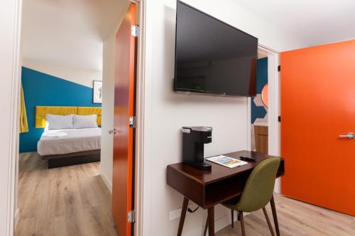 a room with a desk with a television and a bed at 4411 Inn & Suites in Michigan City