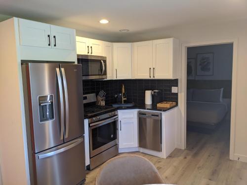 a kitchen with white cabinets and a stainless steel refrigerator at 4411 Inn & Suites in Michigan City