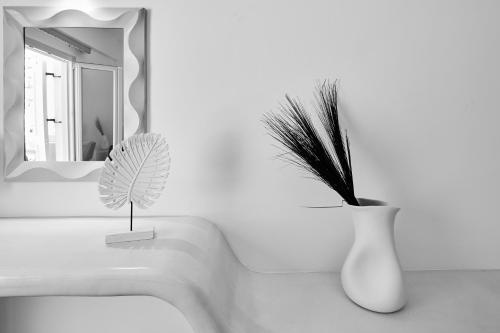 a white vase with a potted plant in a bathroom at Blue Sea Hotel in Kamari