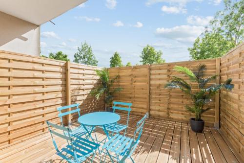 un patio avec une table et des chaises et une clôture dans l'établissement Appartement des Rêves Bleus - Welkeys, à Montévrain