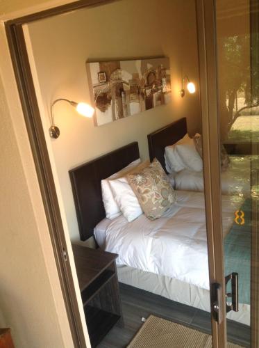 a bedroom with a bed and a mirror at Jock of the Bushveld in Barberton
