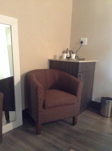 a brown chair sitting in a corner of a room at Jock of the Bushveld in Barberton