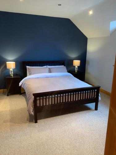 1 dormitorio con 1 cama grande y pared azul en Feather bed 3 bedroom house en Kinsale