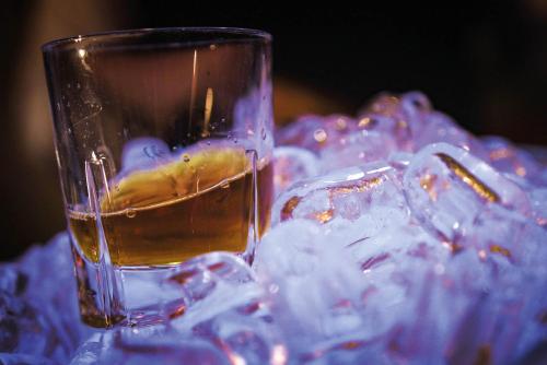a glass of liquid sitting on a table with ice at Seminaris Hotel Potsdam Griebnitzsee in Potsdam