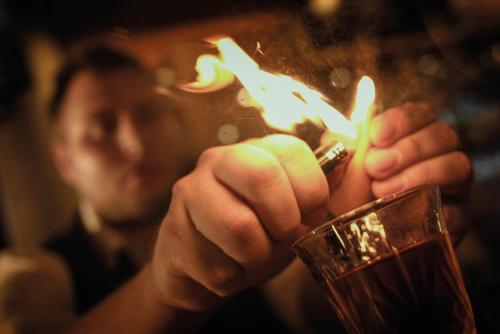 a person holding a lighter and a glass at Seminaris Hotel Potsdam Griebnitzsee in Potsdam