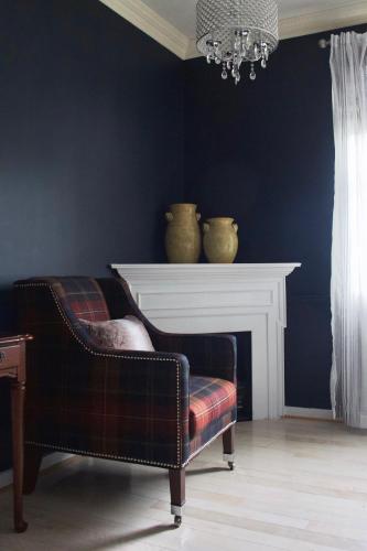 a living room with a chair and a fireplace at The Litchfield Inn in Litchfield