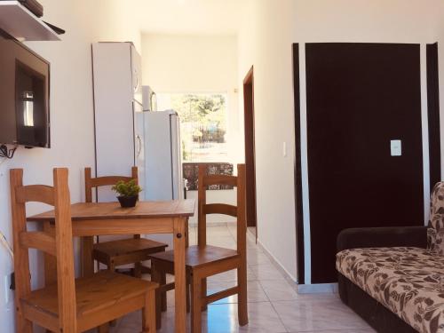 a living room with a table and a refrigerator at Recanto do Valtinho in Florianópolis