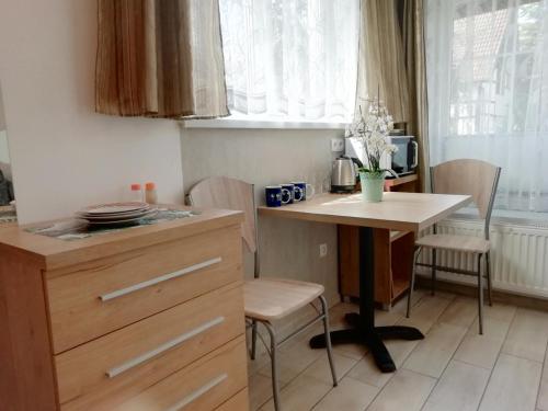 a kitchen with a desk and a table and chairs at Pokoje Gościnne POD DELFINKAMI in Ustka