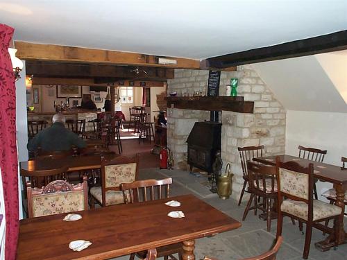 a man sitting at a table in a restaurant with a fireplace at The Fox & Hounds in Faringdon