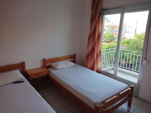 two beds in a room with a window at House Papus in Sarti