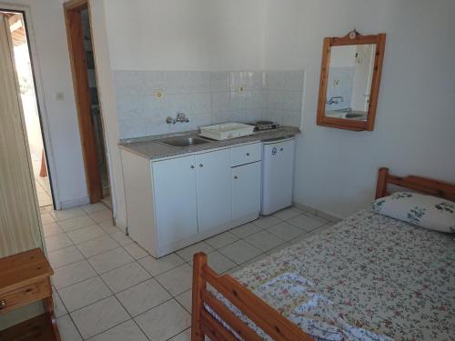 a small kitchen with a sink and a bed at House Papus in Sarti