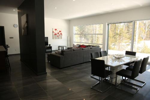 a living room with a table and a couch at Les Chalets du Lac Serein --Serein-- in Saint Ludger de Milot