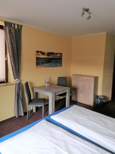 a bedroom with a desk and a table and a bed at Pension Riverside in Leverkusen Hitdorf am Rhein - Zentral an der A1 und 59 in Leverkusen