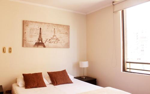a bedroom with a bed and a picture of the eiffel tower at Apartamentos Costanera Centre in Santiago