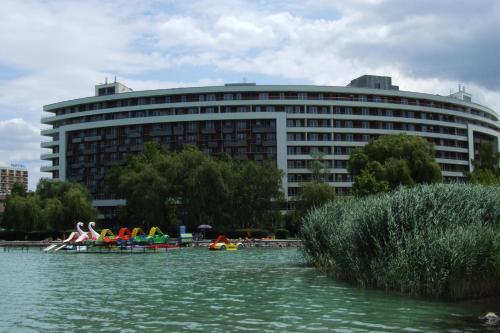 a large building with people in boats in the water at Club218 Wellness Apartments in Siófok