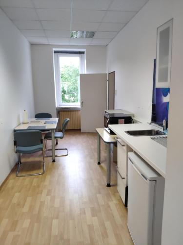 an office with a kitchen with a table and chairs at 1210Apartment in Vienna