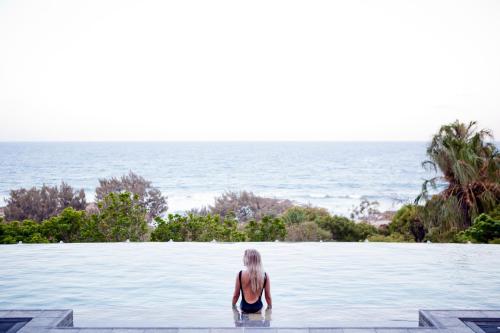 a woman standing in the water looking at the ocean at Sunrise at 1770 Holidays in Agnes Water