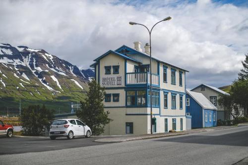 un coche blanco estacionado frente a un edificio en Hotel Aldan - The Post Office en Seyðisfjörður