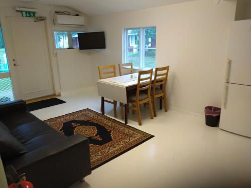 a living room with a couch and a table and chairs at Kvarngården Natur Resort in Byxelkrok