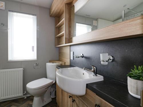 a bathroom with a white sink and a toilet at Pinehurst Lodge in Redruth