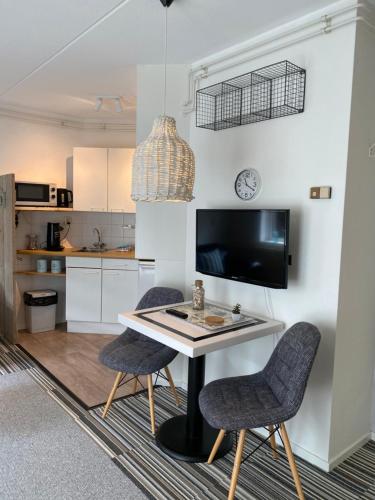a kitchen with a table and two chairs at Texelheerlijk 10 in De Koog