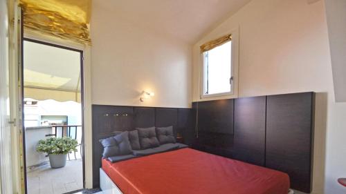 - une chambre avec un lit rouge et une fenêtre dans l'établissement Ai Bareteri Luxury Canal View, à Venise