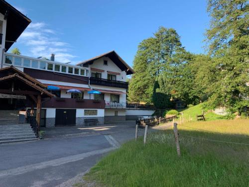 ein großes Gebäude mit einem Zaun davor in der Unterkunft Gasthaus & Pension Zum Fürstengrund in Reichelsheim