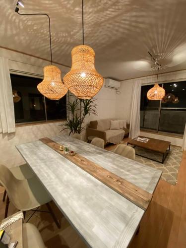 a table in a living room with two lights at #オーシャンビューBBQ可能 #4LDK新築一軒家 #長期滞在歓迎 -- 時空間 凪 Nagi -- in Hyakuna